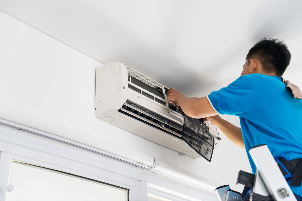 Aircon Repairs in Pretoria Air conditioning technician working on a wall-mounted unit in a Pretoria home